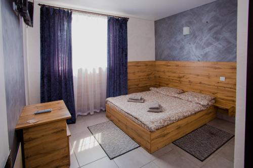 a bedroom with a wooden bed and a window at OK Hotel in Rivne