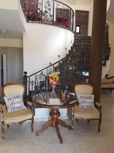 a dining room with a table and two chairs at Larnaca Mansion Ideal for 3 Families or more in Larnaka
