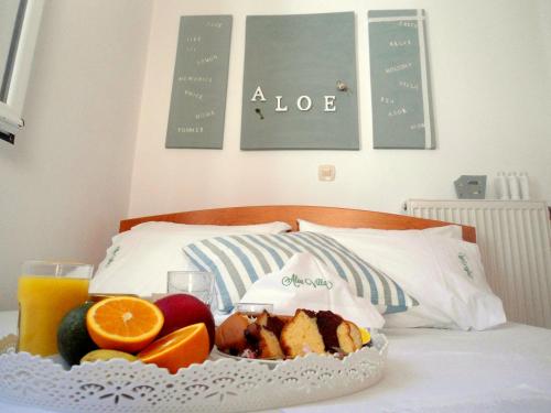 a tray of food on a bed with fruit and juice at Aloe Villa Chania Crete in Georgioupolis