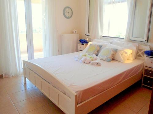 a bedroom with a large bed with two dolls on it at Aloe Villa Chania Crete in Georgioupolis