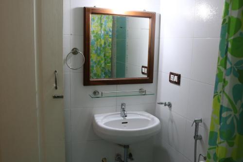 La salle de bains est pourvue d'un lavabo et d'un miroir. dans l'établissement Asian Golden Sands - S7 & S8, à Benaulim