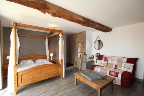 - une chambre avec un lit en bois et une table dans l'établissement Au Petit Bonheur chez Bambina, à Leynes