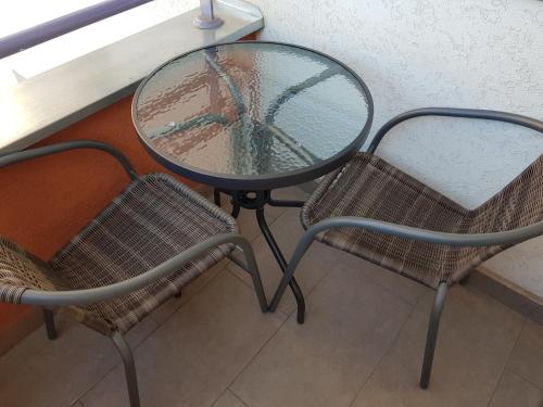 two chairs and a table and a table and two chairs at Apartment GEA 18 in Novi Sad