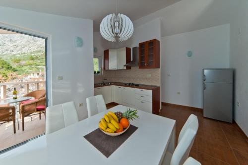 a kitchen with a table with a bowl of fruit on it at Villa Nika in Drasnice