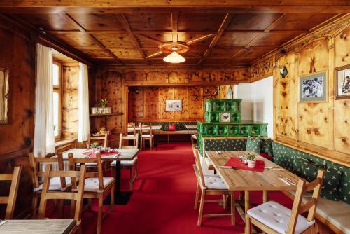 ein Restaurant mit Holzwänden, Tischen und Stühlen in der Unterkunft Landhaus Albert Murr - Bed & Breakfast in Sankt Anton am Arlberg