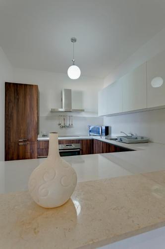 a white vase sitting on a counter in a kitchen at Seafront Apartment Sliema in Sliema