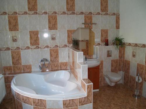 ein Badezimmer mit einer großen Badewanne und einem WC in der Unterkunft U Nás in Smržovka