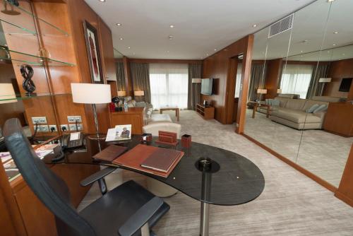 a large room with a desk and a living room at Hotel Tiama Abidjan in Abidjan