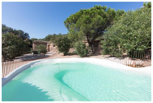 una piscina en un patio con una valla en Ranch Campo Palombaggia, en Porto Vecchio