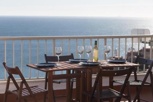 a table with glasses and a bottle of wine on a balcony at Lighthouse Cullera Penthouse in Cullera