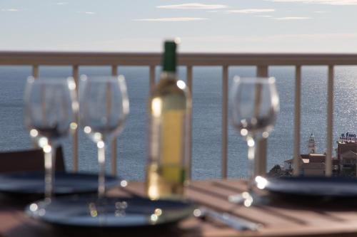 a table with wine glasses and a bottle on a balcony at Lighthouse Cullera Penthouse in Cullera