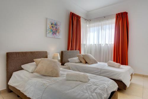 a bedroom with two beds and a window at Seafront Apartment Sliema in Sliema
