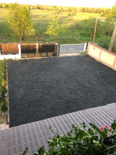 a yard full of black gravel with a fence at Smiley Rooms in Avrig