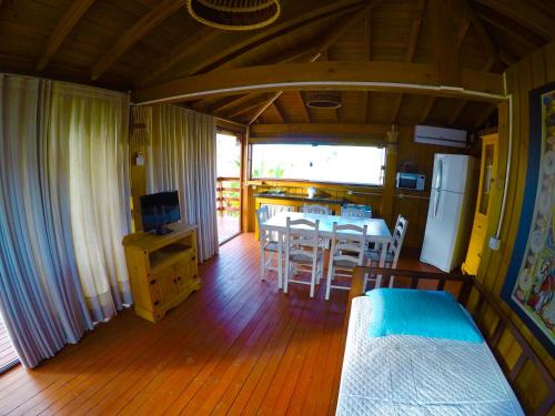 una cucina e una sala da pranzo con tavolo e frigorifero di Bangalô com vista para o mar. a Governador Celso Ramos