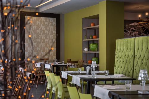 a dining room with tables and yellow chairs at Hotel Europa in Breuil-Cervinia