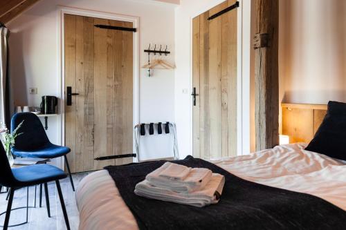 a bedroom with a bed with two towels on it at Bed & Breakfast De Schoppe in Winterswijk