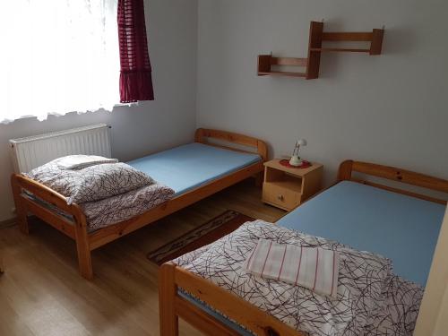 a room with two beds and a table at Newland Wójtowicz in Debrznica