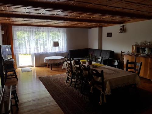 Una sala de estar con una mesa y sillas y un sofá. en Newland Wójtowicz, en Debrznica