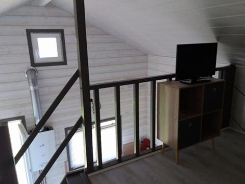 Cette chambre dispose d'un escalier et d'une télévision à écran plat. dans l'établissement Petit Chalet Chez Marcelline, à Amécourt