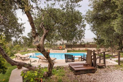 a swimming pool in a yard with a tree at Villa Aloni in Fílippos