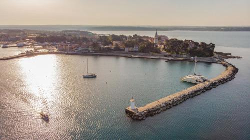 an island with a lighthouse and boats in the water at Apartments Pepe in Novigrad Istria