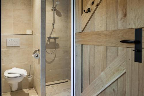 two pictures of a bathroom with a shower and a toilet at Bed & Breakfast De Schoppe in Winterswijk