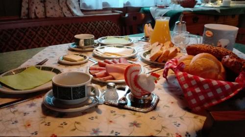 a table with a breakfast of bread and coffee on it at Privatpension Gosaukammblick in Gosau