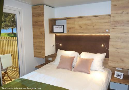 諾維格勒半島的住宿－Camping Home Adriamar，一间卧室配有一张带木制床头板的床