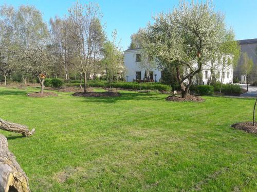 a yard with trees and a white house at Centrum Konferencyjne Brancon in Babimost