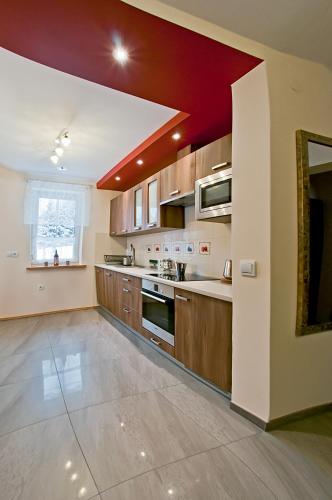 a large kitchen with wooden cabinets and a red ceiling at Miodowy Zakątek in Łabowa