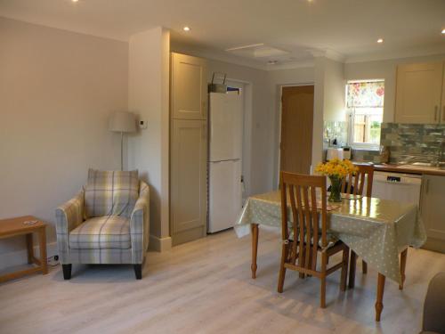 cocina y comedor con mesa y sillas en Woodfield Self-Catering apartment en Cambridge