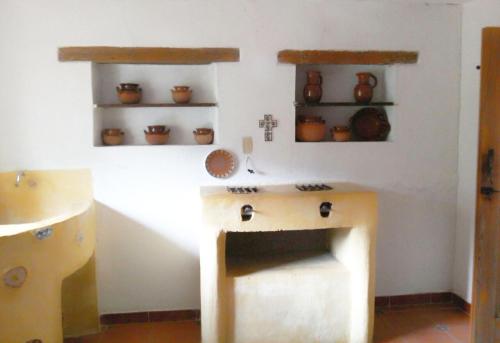 a kitchen with a counter and a sink and shelves at La Casona Breakfast & Wellness Center in Temascaltepec de González