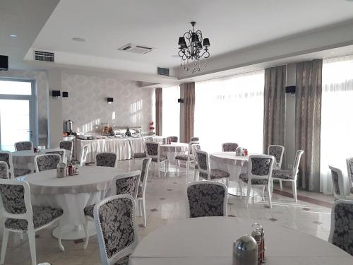 a dining room with white tables and chairs at Hotel SAX Gračanica in Gračanica