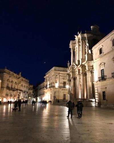 a group of people walking in front of a building at night at B&B Villa Dunardi in Fontane Bianche