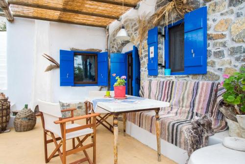 MirsíniにあるThe Architect's Village Houseの青いキャビネット付きの客室で、テーブルと椅子が備わります。