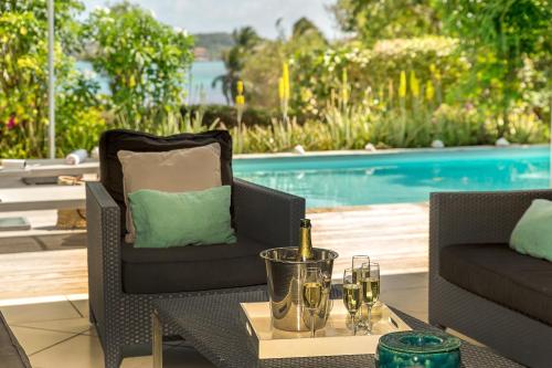 a table with a bottle of wine and glasses on it at Villas Palm in Le Vauclin