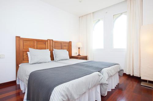 コスタ・テギセにあるAna Iris Playa de Jablilloの白いベッドルーム(大型ベッド1台、窓2つ付)