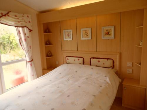 a bed in a bedroom with a window at Peace and quiet in countryside location near Perranporth in Perranzabuloe