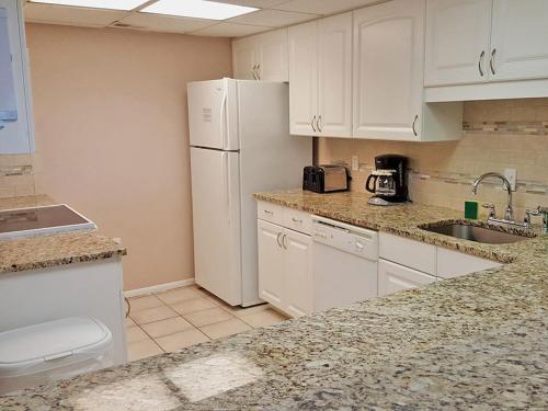 uma cozinha com armários brancos e um frigorífico branco em Seawatch at Island Club by Capital Vacations em Hilton Head Island
