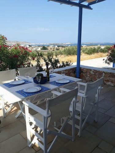 a white table with chairs and an umbrella at S & K Maisonnettes in Pounda