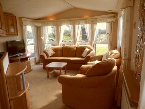 a living room with two couches and a tv at Peace and quiet in countryside location near Perranporth in Perranzabuloe