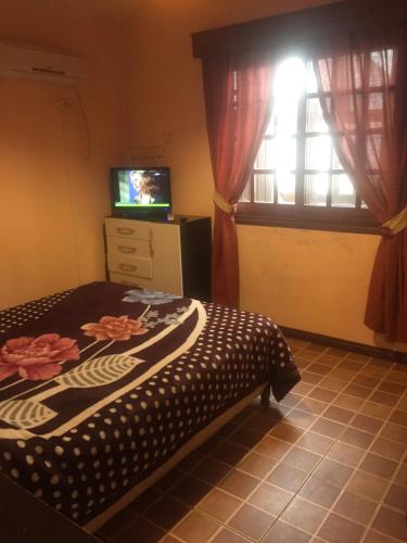 a bedroom with a bed and a window with a television at Complejo Casas del Mirador in Barra del Chuy