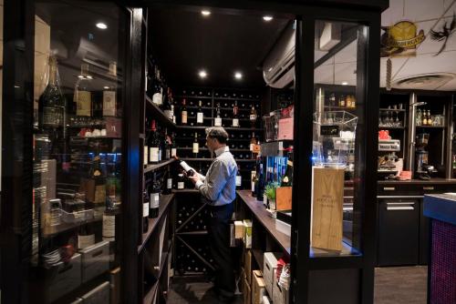 a man standing behind a counter in a wine store at ibis Metz Nord in Woippy