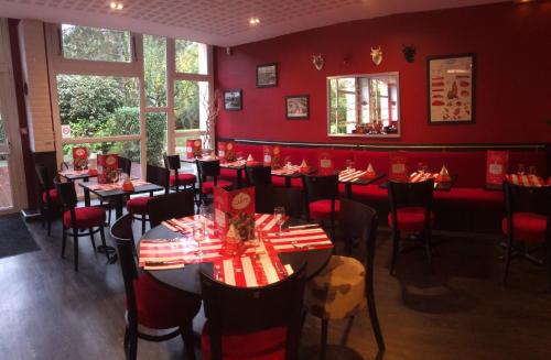 a restaurant with red walls and tables and chairs at ibis Metz Nord in Woippy
