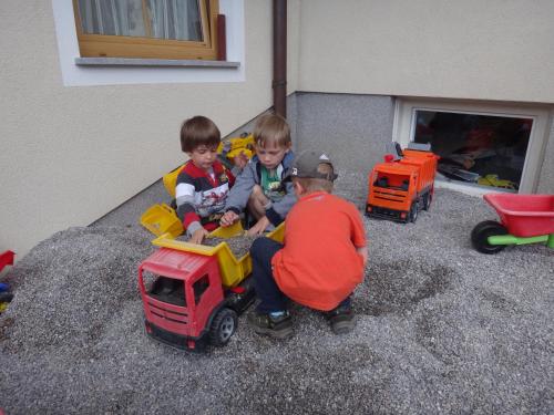 a group of three children playing with toy trucks at Appartement Fritzenwallner in Wagrain