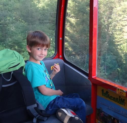 a young boy sitting in a seat on a bus at Appartement Fritzenwallner in Wagrain