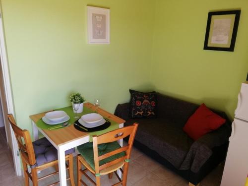 a living room with a table and a couch at Panoramic view studio in Rab