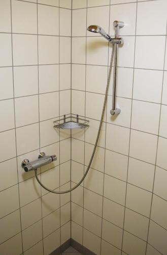 a shower with a hose in a bathroom at Otepää Apartments in Otepää