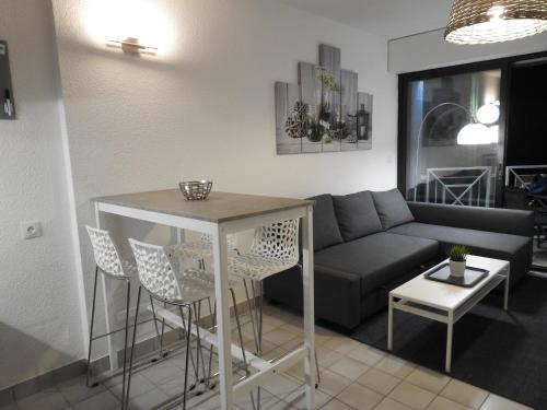 un salon avec un canapé, une table et des chaises dans l'établissement Résidence Casino, à Andernos-les-Bains