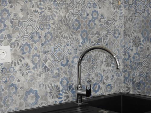 Un fregadero de cocina con un grifo en la pared en Résidence Casino, en Andernos-les-Bains